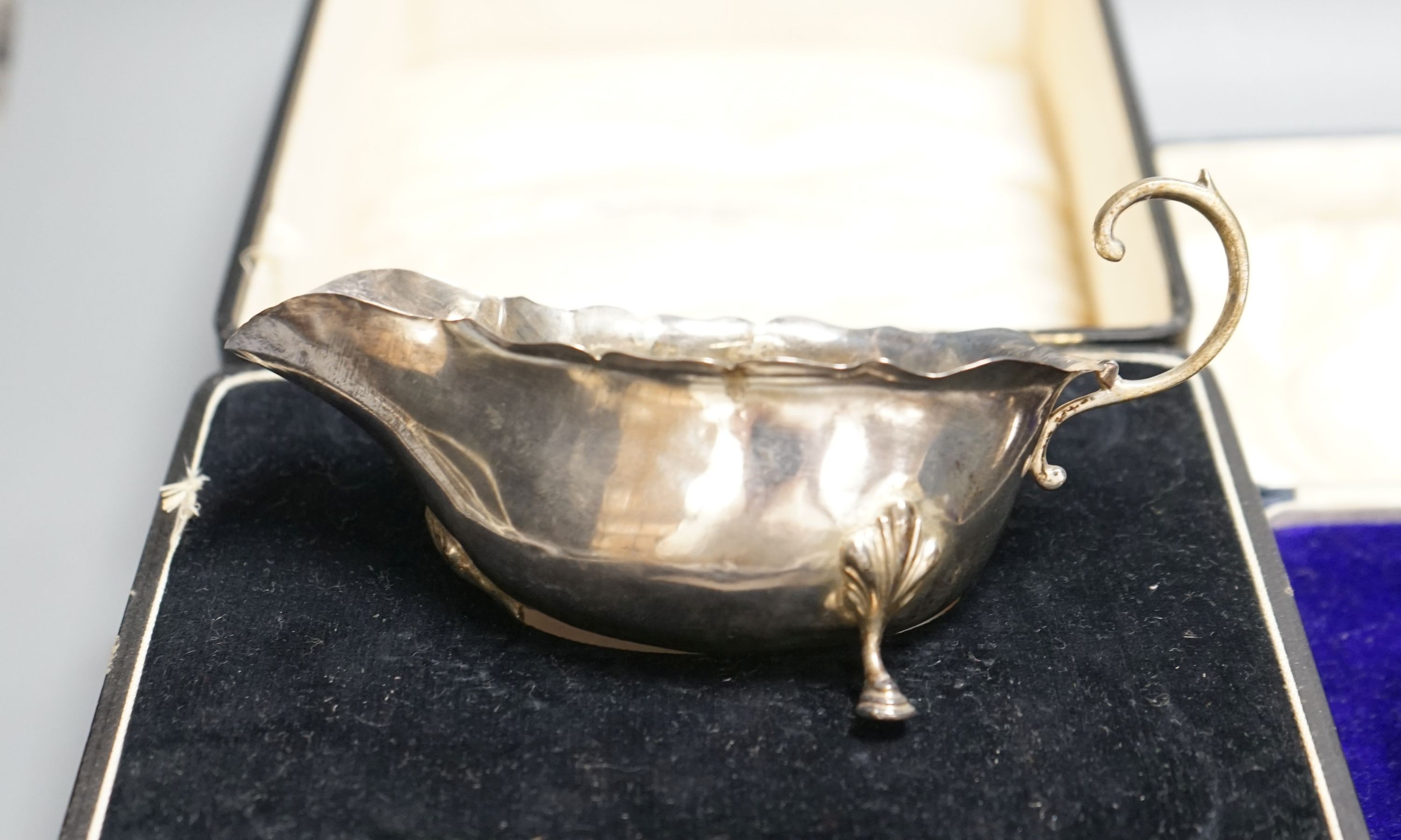 A cased George V silver three handle bowl and spoon, Birmingham, 1928 and a silver sauceboat, 7oz.